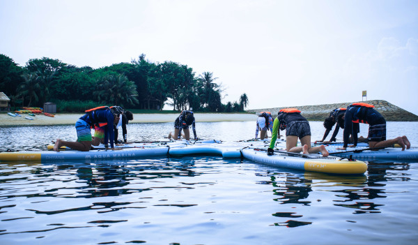 A group of people practicing yoga on paddleboards in the water.